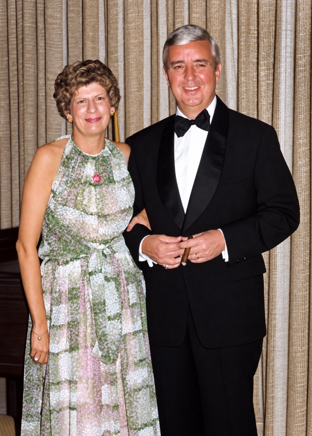Formally dressed couple in front of curtains before the background change