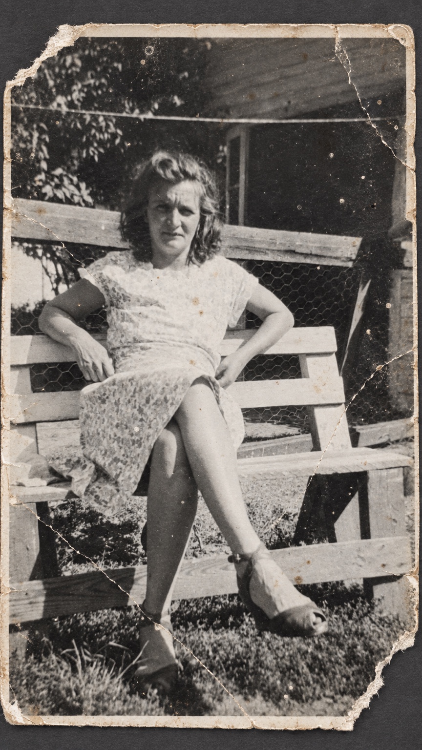 Damaged outdoor portrait of a seated woman before restoration